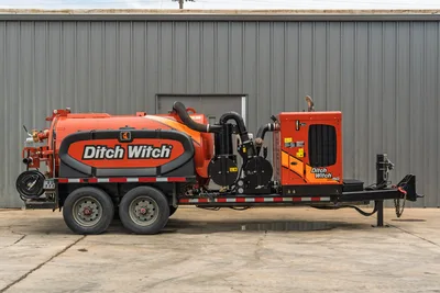 2023 Ditch Witch HX50 mud recycler, driver-side profile, orange elliptical tank, vacuum hose, pump assembly, engine unit, tandem axle trailer