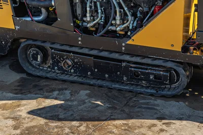 2016 Vermeer D23x30 S3 rubber track close-up showing hydraulic lines, fittings, and used undercarriage detail