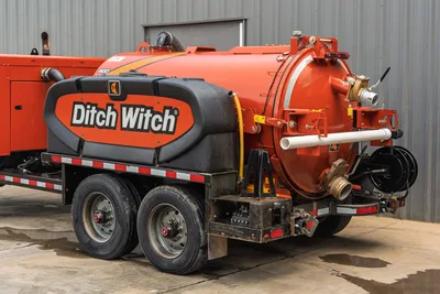 2023 Ditch Witch HX50 mud recycler, rear 3/4 view, orange vacuum tank, dual-axle trailer, visible hose connections, manifold, and fill ports