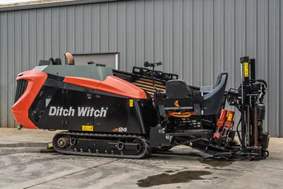 2024 Ditch Witch JT24 HDD drill, side view, rubber tracks, operator seat, drill pipe rack loaded, carriage assembly visible