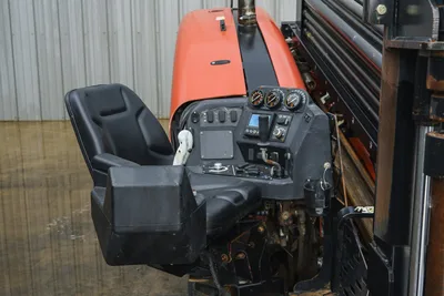 2015 Ditch Witch JT20 operator station showing black seat, control console, gauges, joystick, and display screen with red engine hood