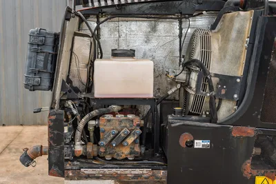 2016 Ditch Witch JT25 open engine compartment showing hydraulic valve block, coolant reservoir, and cooling fan