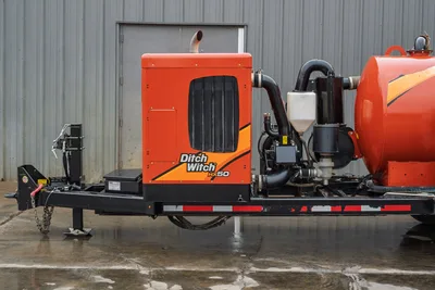 2021 Ditch Witch HX50 mud recycler, side view showing engine enclosure, exhaust stack, pump assembly, piping, and orange tank on trailer