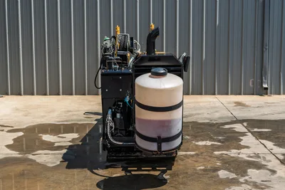 2021 Vermeer D8x12 HDD drill rear view showing drilling fluid mixing tank, hydraulic hoses, engine exhaust stack, and frame