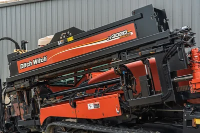 2012 Ditch Witch JT3020 Mach 1 drill rack assembly, side profile, clear visibility of rack, carriage, and rubber tracks.