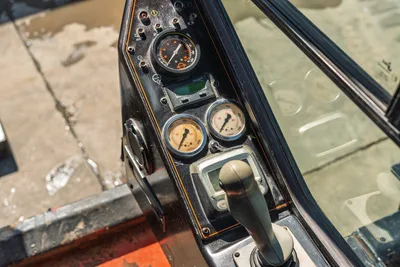 2014 Ditch Witch JT100 Mach 1 cab instrument panel showing tachometer, dual pressure gauges, Durant hourmeter, and joystick control