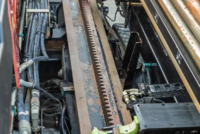 2021 Ditch Witch JT28 thrust rack, hydraulic hoses, and drill pipe visible; worn rack teeth with surface rust, used condition
