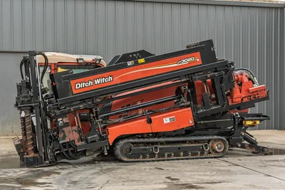 2012 Ditch Witch JT3020 Mach 1 HDD drill, side profile view showing rack, tracks, drill pipe, and carriage assembly.