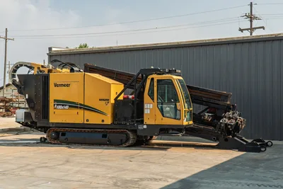 2017 Vermeer D100x140 S3 HDD drill, full profile view, rubber tracks, enclosed cab, loaded drill pipe rack, carriage visible