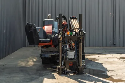Rear view of 2020 Ditch Witch JT24 HDD showing operator seat, drill rack with pipe, hydraulic stabilizers, and engine cover.
