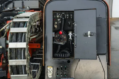 2015 Ditch Witch JT20 open control panel showing joystick, ignition, toggle switches, fluid coupling, and track drive chain closeup