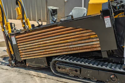 Vermeer 10x15 S3 HDD rig side view with 6-foot drill pipe loaded, tracked undercarriage, and control cab visible