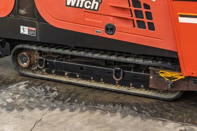 2012 Ditch Witch JT3020 Mach 1 steel tracks and undercarriage side profile with motor housing and warning decals.