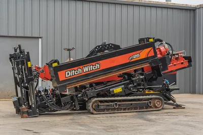 2021 Ditch Witch JT25 horizontal directional drill, side profile showing tracks, drill pipe rack, and carriage assembly.