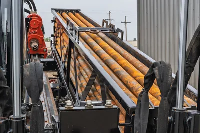 Ditch Witch AT40 drill pipe rack and HDD rotary carriage, high-angle view of loaded 3-inch drill string components.