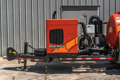 2023 Ditch Witch HX30 mud mixing unit, trailer-mounted, front 3/4 view showing engine enclosure, exhaust stack, pump assembly, and mixing tank.