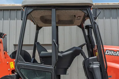 2024 Ditch Witch RT125Q open operator cab, black seat and steering column, ROPS canopy, orange bodywork visible