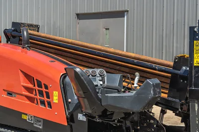 2021 Ditch Witch JT20 operator station, side-angle view showing controls, drill pipe rack, engine cover, and safety decals.