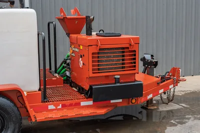 2015 Ditch Witch MR90 mud mixer rear view on trailer, showing hopper, engine cooling louvers, hydraulic lines, grating, and tow hitch