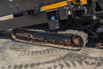 2021 Vermeer D40x55 S3 HDD drill right-side rubber track, close-up overhead angle, worn with mud buildup, hydraulic components visible above