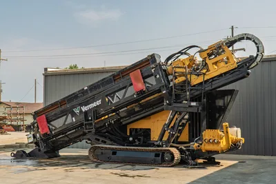 2017 Vermeer D100x140 S3 HDD drill, side view, angled thrust frame raised, drill pipe loaded, carriage assembly, tracks, mud pump visible