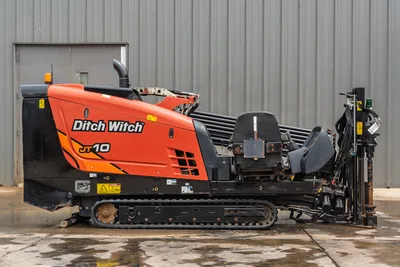 2018 Ditch Witch JT10 HDD rig, profile view, showing track undercarriage, engine housing, operator seat, and drill rack.