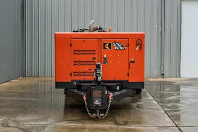 2021 Ditch Witch HX50 mud recycler, front view, orange enclosed unit, trailer hitch with safety chains, vented enclosure panels, intake hose visible on top