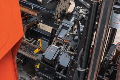 2016 Ditch Witch JT25 drill frame close-up, overhead view showing vise assembly, hydraulic lines, and pipe-handling components with wear.