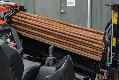 2016 Ditch Witch JT9 drill pipe rack loaded with used 1.66" HDD drill rods; operator seat and joystick controls visible