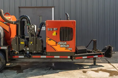 2022 Ditch Witch HX30 mud mixing unit on trailer, side view showing orange engine enclosure, pump assembly, hoses, and gauges