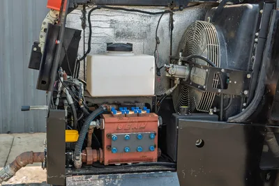 2017 Ditch Witch JT30 open engine compartment showing Dean mud pump, hydraulic lines, coolant reservoir, and radiator fan