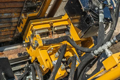Vermeer 10x15 S3 drill head assembly overhead view showing yellow rotary head, 1.66" drill pipe, hydraulic hoses, and operational wear.