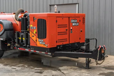 2023 Ditch Witch HX75 mud recycler on trailer, 3/4 front view, orange enclosure, louvered panels, pump assembly, hose connections, tongue with safety chains