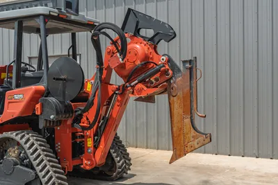 2024 Ditch Witch RT125Q trencher boom arm with vibratory plow attachment raised, rubber tracks, hydraulic hoses visible