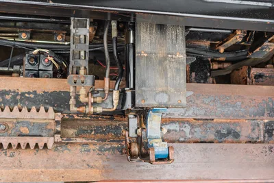 Close-up of Ditch Witch JT4020 MACH 1 carriage, hydraulic hoses, and pipe wrestling assembly on the drill rack.