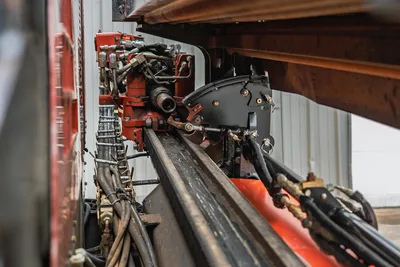 2018 Ditch Witch JT20 HDD carriage assembly, drill string rack, hydraulic lines, and rotation systems, side-angle view.