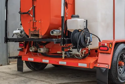 2015 Ditch Witch MR90 mud recycler rear frame detail showing fill ports, hose reel, manifold valves, and trailer axle