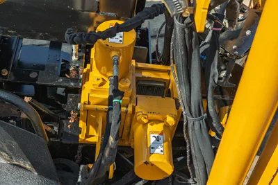 2022 Vermeer D23x30 S3 HDD rotary drive gearbox close-up, yellow hydraulic motors, bundled hoses, warning labels visible