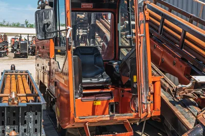 2014 Ditch Witch JT100 Mach 1 open cab door showing operator seat, controls, drill pipe rack with 3.5" pipe visible