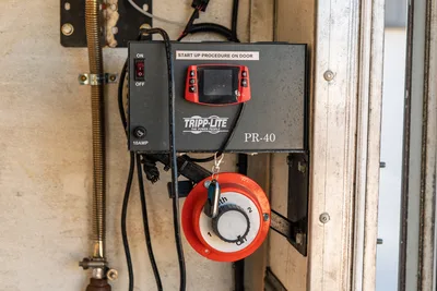 Tripp-Lite PR-40 power supply unit mounted in 2000 Freightliner FL80 mud truck with red rotary electrical battery switch.