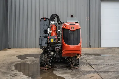 2024 Ditch Witch JT24 HDD drill, rear view showing rotary drive, hydraulic hoses, pipe rack, rubber tracks, and engine hood