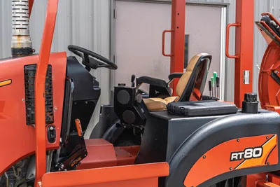 2017 Ditch Witch RT80 operator station side view showing steering wheel, controls, seating, and engine housing detail.