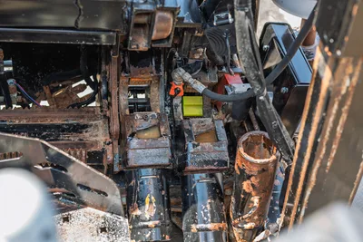 2023 Ditch Witch JT20 overhead view of worn carriage assembly, hydraulic components, drive chains, and mud-coated drill rod holders