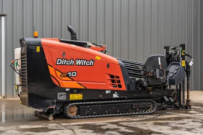 2018 Ditch Witch JT10 HDD drill, side profile view showing engine cowling, operator seat, tracks, and drill pipe magazine.