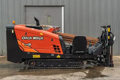 2016 Ditch Witch JT9 HDD drill, full side profile, rubber tracks, loaded drill pipe rack, operator seat, joystick controls, drill frame visible
