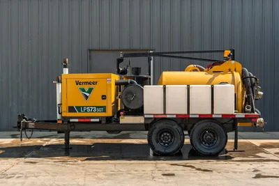 2024 Vermeer LP573SGT vacuum excavator, side view showing dual-axle trailer, spoil tank, water tanks, and boom assembly.
