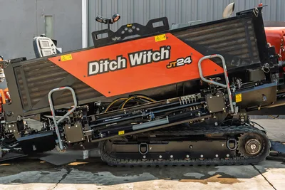 Side profile of 2020 Ditch Witch JT24 HDD drill showing engine housing, steel tracks, and pipe loader assembly in good condition.