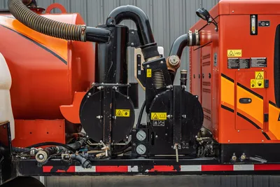 2021 Ditch Witch HX50 mud mixer pump assembly, dual black centrifugal pumps, pressure gauges, discharge piping, caution labels, orange tank visible