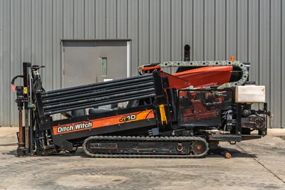 Side view of 2018 Ditch Witch JT10 HDD drill with rubber tracks, pipe rack, and exposed engine compartment in good condition.