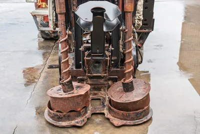 Front view of Ditch Witch JT4020 MACH 1 drilling head assembly with dual auger attachments and rusted drill components.